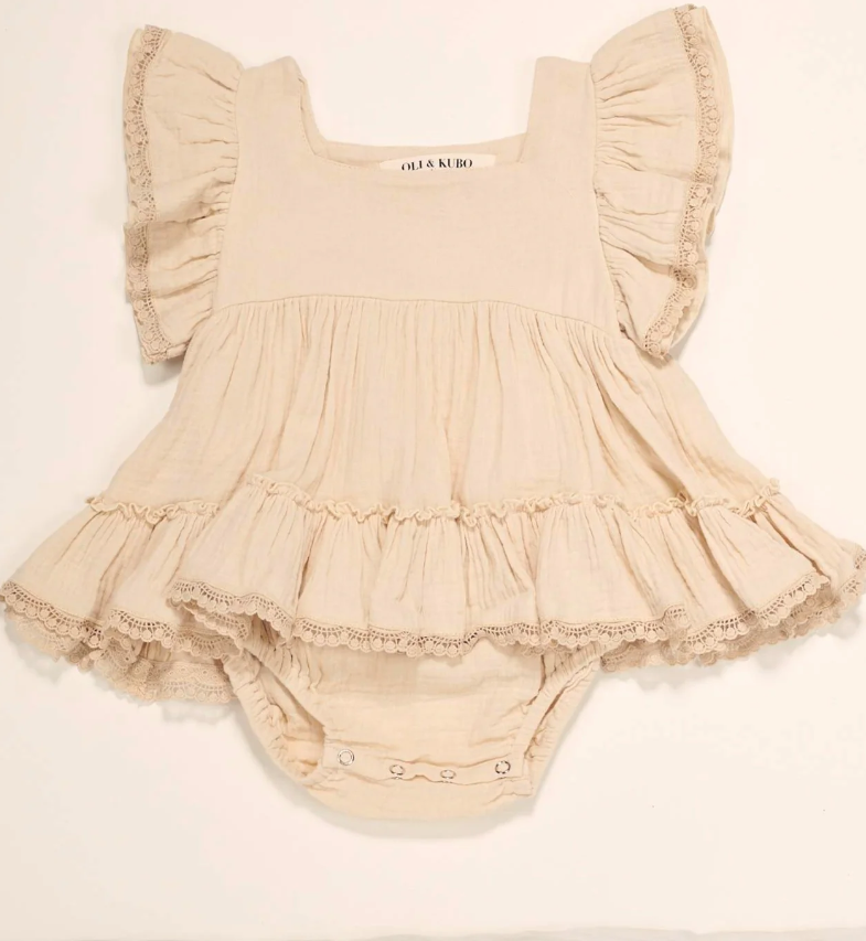 Romper dress for baby girls made from 100% cotton, featuring snap closures and vintage-inspired crochet trim sleeves.