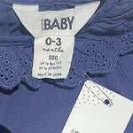 Close-up of lace fabric texture and navy color of baby top
