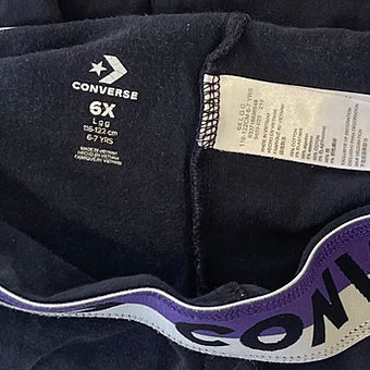 Side detail showing Converse logo on black leggings for girls