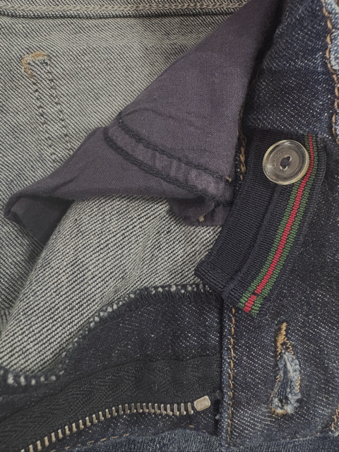 Close-up of Gucci logo tag on kids’ denim jeans
