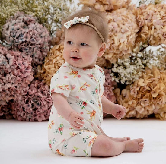 Front view of the Taylor Flora organic baby romper with floral design